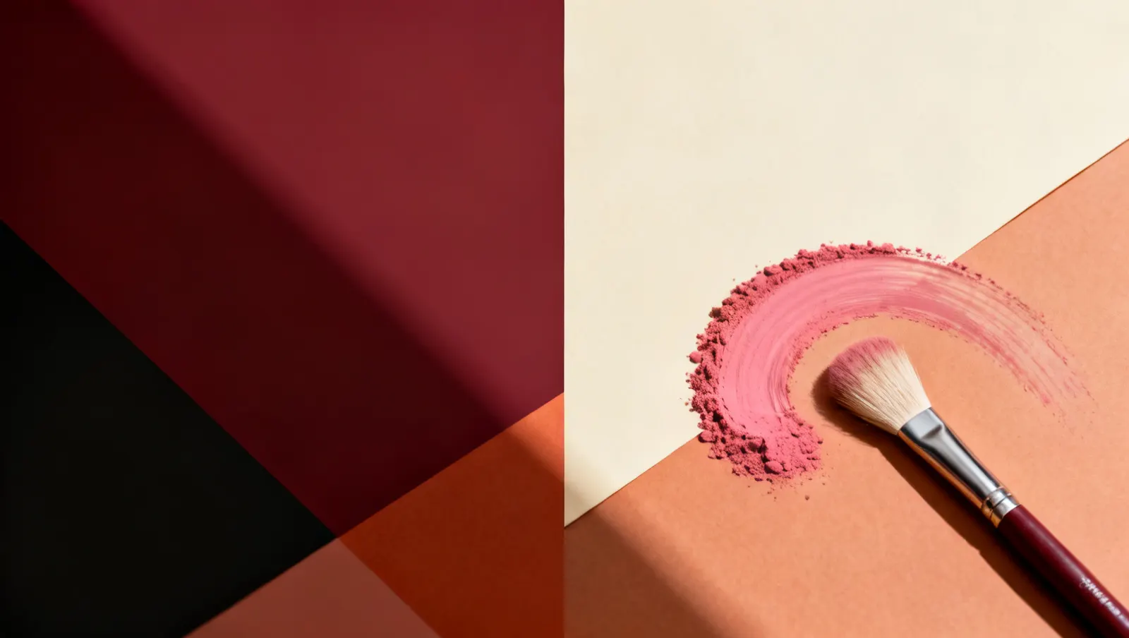Natureza-morta em luz lateral dura: um arco de pigmento varrido e um pincel sem marca de cerdas claras, sobre fundo vinho e creme
